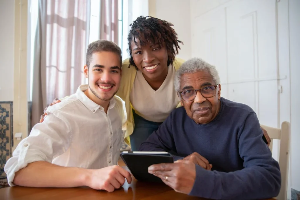 Elderly Person With Tablet Getting Help Using It From Young Carer