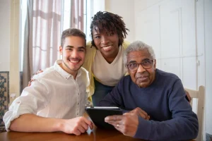 Elderly Person With Tablet Getting Help Using It From Young Carer